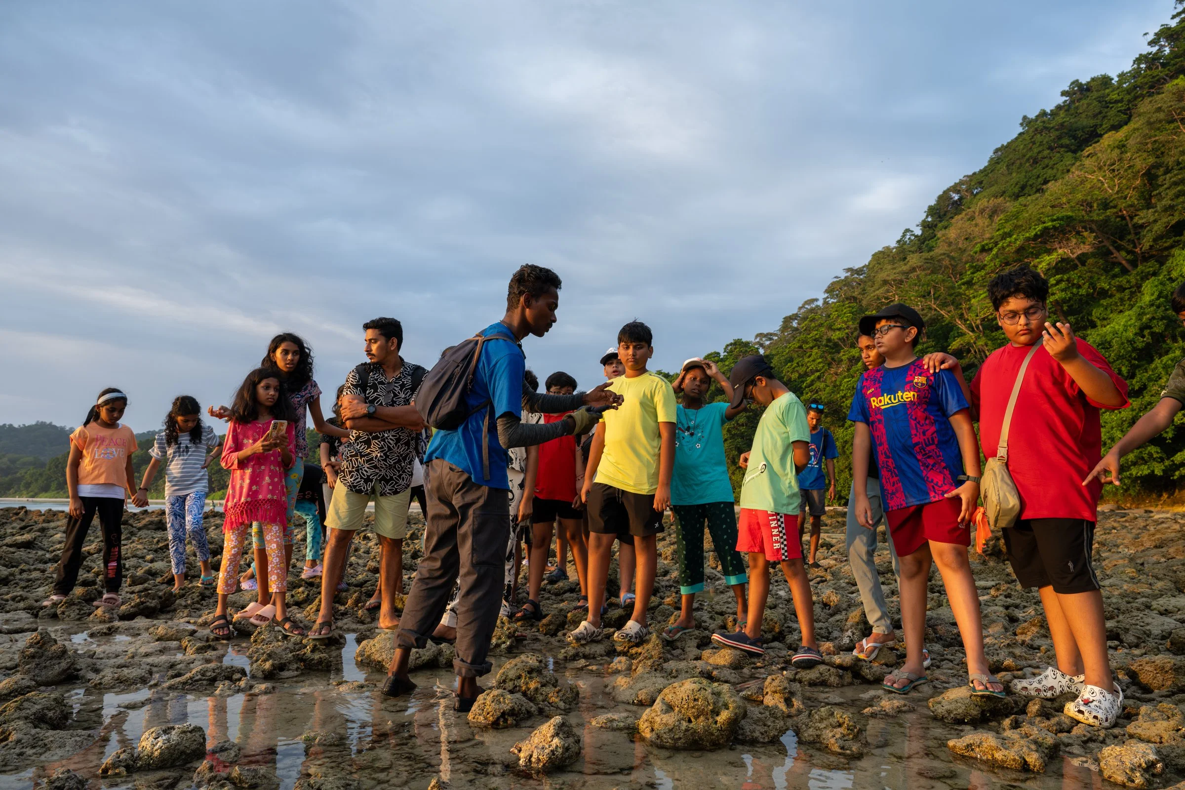 A group exploring exposed rocks and tide pools along a shore